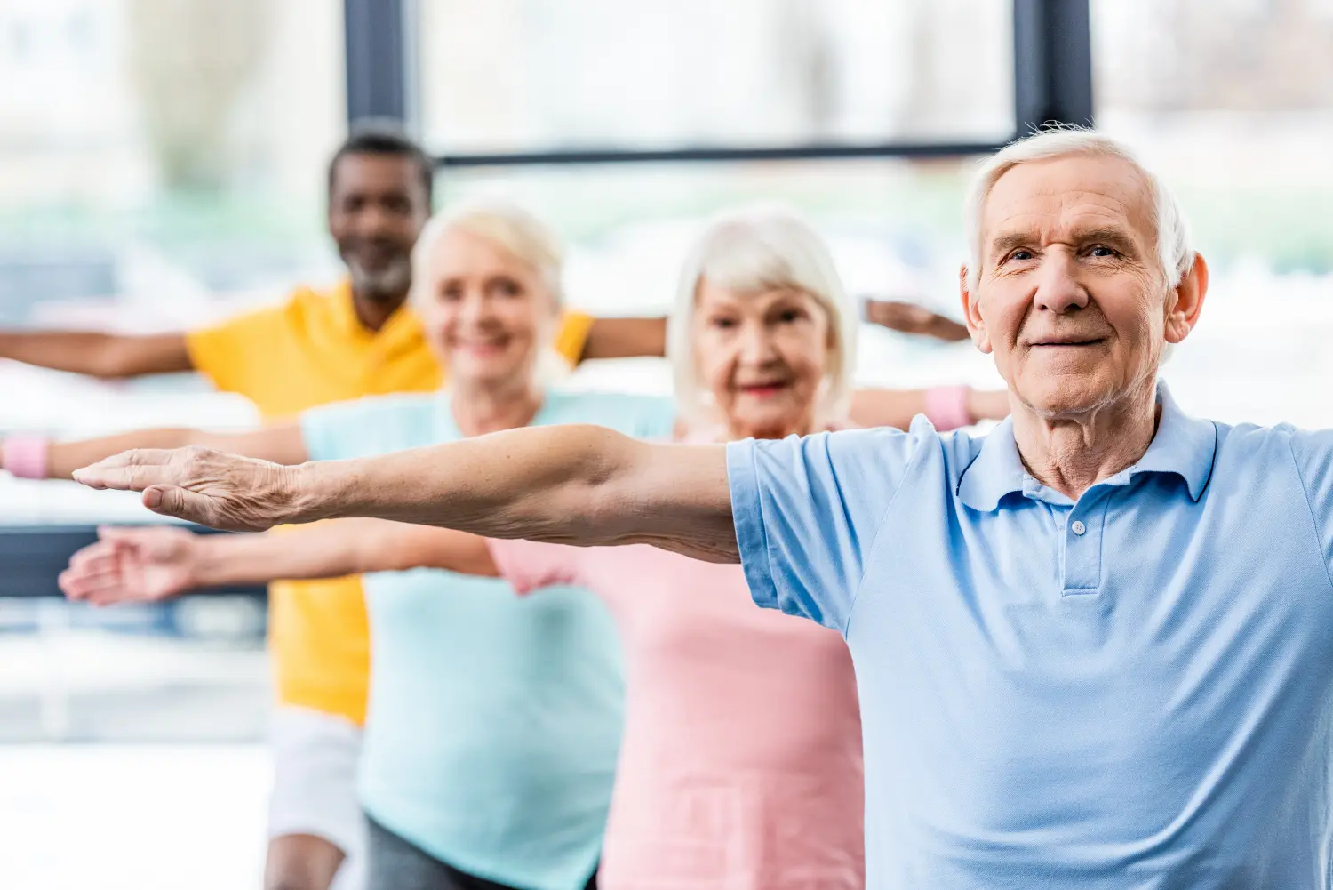 Selektiver Fokus multikultureller Seniorensportler, die synchron im Fitnessstudio trainieren